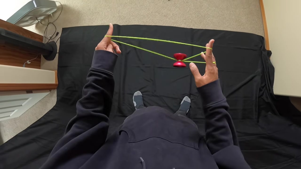 A close view of hands and string during a yo-yo trick.